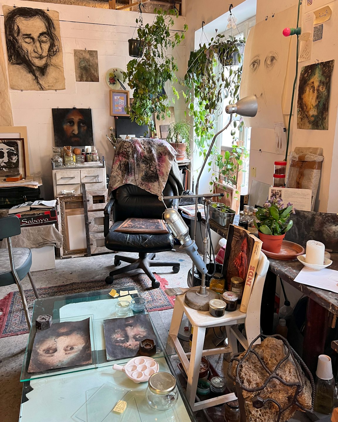Künstleratelier voller Kunstbedarf und bunter Gemälde.