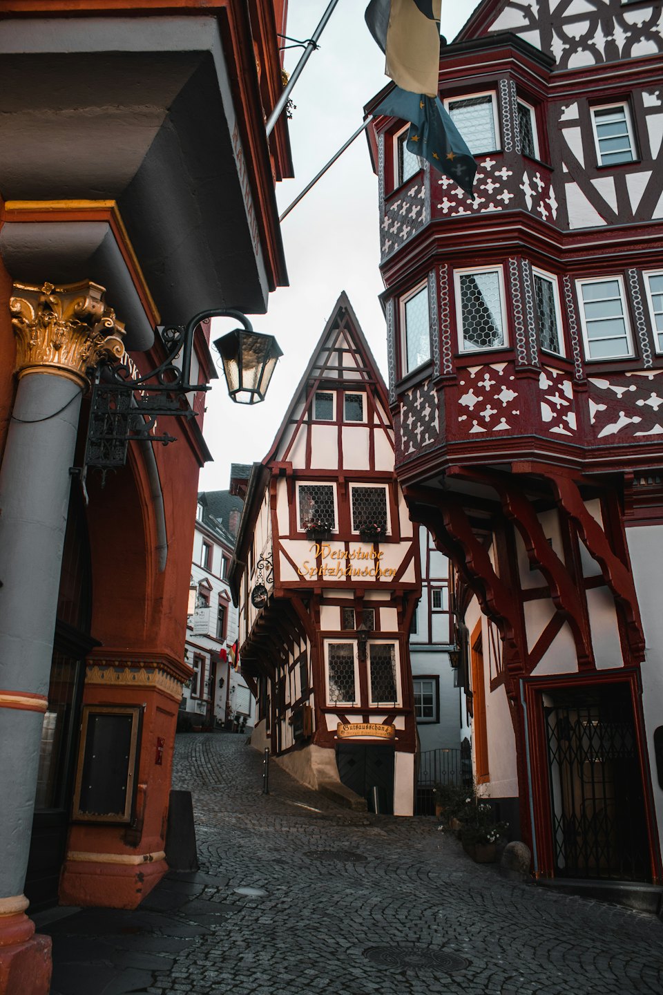 Traditionelle Fachwerkhäuser säumen eine schmale, gewundene Kopfsteinpflasterstraße.